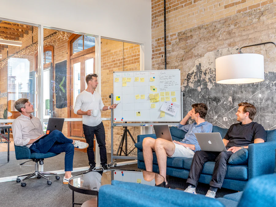 A small team listening to a presentation at a whiteboard